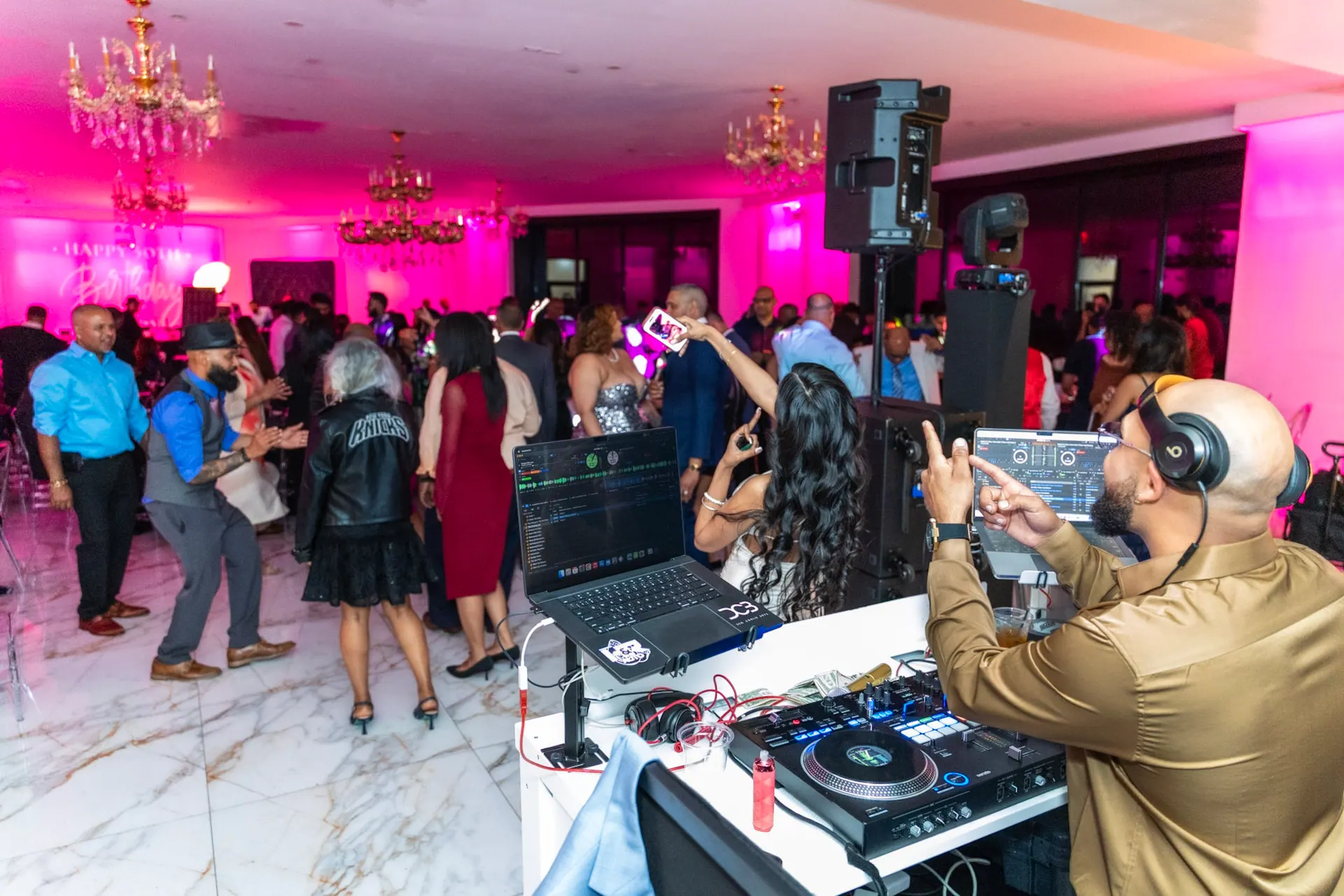 RAHH at the booth with a full dance floor behind him, the room washed in magenta light